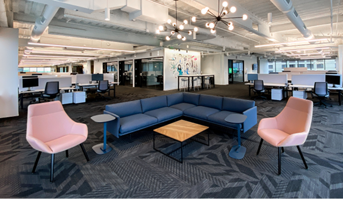 La oficina de Sprout Social en Seattle, un espacio de planta abierta con un gran sofá en forma de L, dos sillones y una mesa de madera.