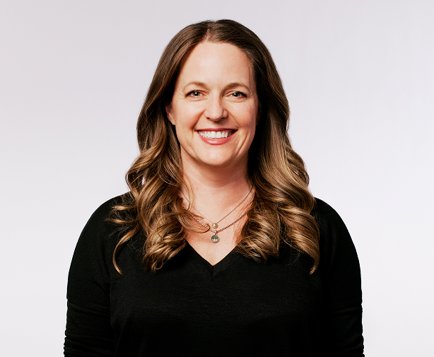 Primer plano de Colleen Geiselhart, vicepresidenta sénior de experiencia del cliente, con un top negro.